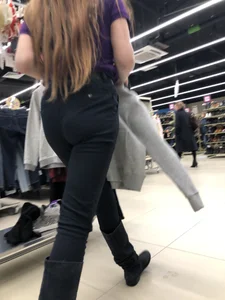 Cute candid shop assistant wearing boots and tight pants
