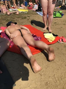 Hot beach candid chick covering her ass with sun lotion