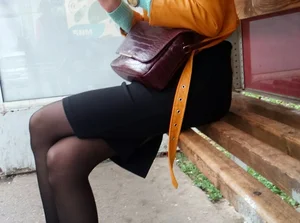 Skinny Tall Girl Sitting in the Bus Stop with Crossed Legs in Black Pantyhose