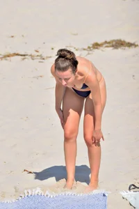 Blue bikini girl on the beach with a great ass and a little pussy lips slips