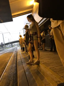 Cute Teen in Shorts on the Tram Stop