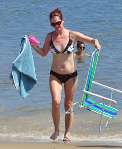 Tattooed redhead milf in a bikini at the beach