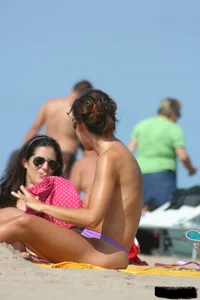 2 topless girls at the beach in thongs