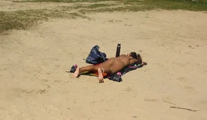 Sexy girl getting some sun laying on the beach in thong bikini