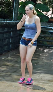 Cute blonde in denim shorts and a wet top