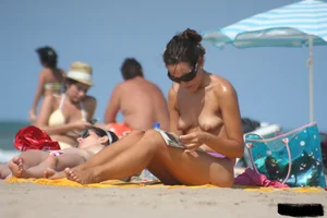 2 topless girls at the beach in thongs