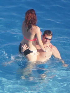 Sexy red haired girl in pink and black bikini at the pool