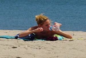 Sexy ass blonde milf on the beach in a thong with cameltoe and bending over