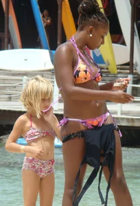 Sexy black babe in various bikinis on the beach while on vacation