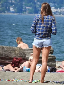 Beach babe taking off her shorts and shirt showing her bikini and sexy body