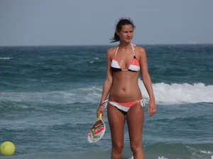 Skinny and sexy lady in a bikini playing on the beach