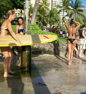 Skinny blonde surfer on the beach in little bikini