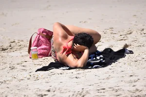 Huge boobed thick brunette babe on the beach in a bikini