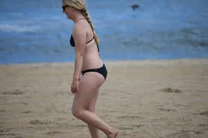 Chunky blonde in a black bikini on the beach