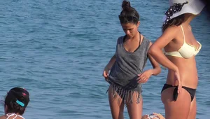 A sexy skinny girl on the beach in a bikini with sexy friends in bikinis