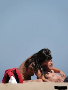 Topless lady on the beach in a gold thong with a nice ass