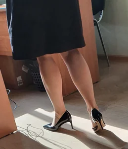 Hot teacher wearing stiletto heels and a skirt in classroom