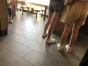 Couple of candid teens in shorts making order in fast food restaurand creepshots