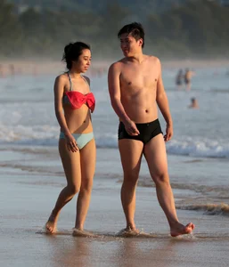 Cute Asian in bikini on the beach with her boyfriend