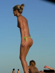 Bunch of sexy babes on the beach topless and in thong bikinis