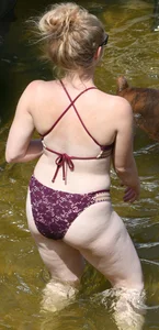 Chunky blonde enjoying some drinks in the water in her purple bikini