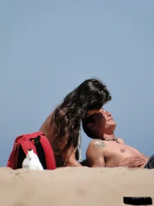 Topless lady on the beach in a gold thong with a nice ass