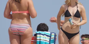 Two thick white girls in bikinis on the beach with big asses