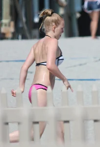 Skinny blonde girl on the beach in her pink and white bikini