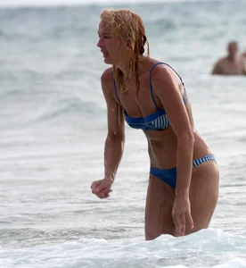 Blonde milf in a blue bikini looking sexy at the beach