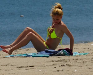 Sexy ass blonde milf on the beach in a thong with cameltoe and bending over