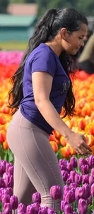 Cute babe in tight leggings taking pictures in flower fields