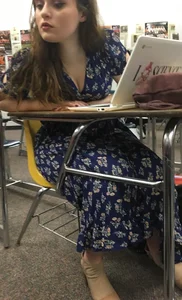 Hot Student Girl in a Long Dress Sitting at the Desk, Closeup of Her Legs