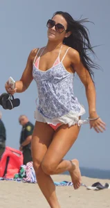 Trio of girls in bikinis on the beach and one with an incredible ass