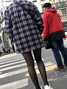 Cute candid girl with legs in black pantyhose waiting on the crosswalk