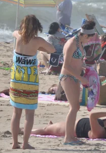 Bikini girls setting up for a day on the beach in their bikinis