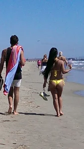 Beach babe with a nice ass and big tits in yellow thong bikini