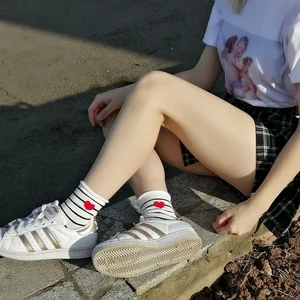 Girl in a Skirt and Cute Socks Sitting on the Street Curb Candid Photo