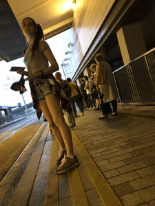 Cute Teen in Shorts on the Tram Stop