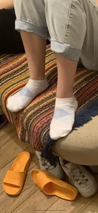 Young Girl in Pants And White Socks Sitting on the Couch Home Creepshot