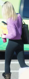Beautiful skinny blonde in tight leggings and purple crop top showing sexy stomach