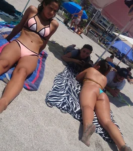 2 beach friends in bikinis,one thick and in a thong
