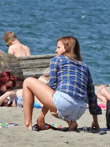 Beach babe taking off her shorts and shirt showing her bikini and sexy body