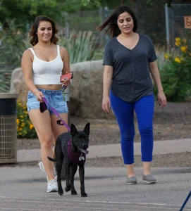 Sexy dog walker in shorts and tank top with friend in blue jeans