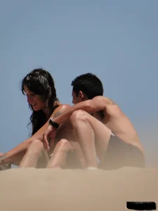 Topless lady on the beach in a gold thong with a nice ass
