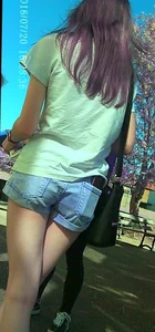 Skinny girl with purple hair in denim shorts