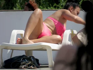 Smoking brunette in pink thong at the pool with camel toe