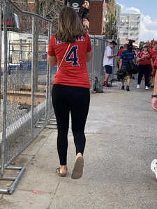 Bunch of girls in various outfits at a Cardinals baseball game