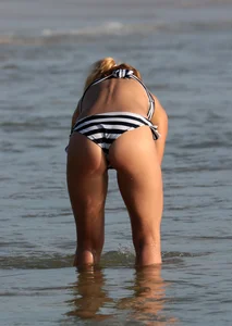 Skinny sexy blonde in little striped bikini in the water