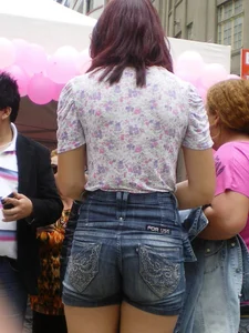 Redhead girl with her cheeks eating her denim shorts