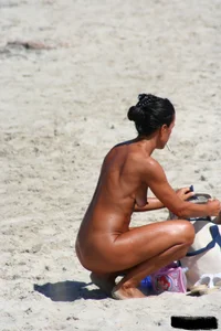 Smoking milf at a nude beach with a hairy pussy
